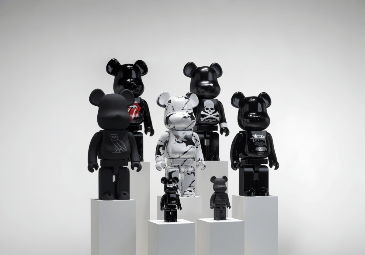 Category side 1000% Bearbricks new Stylized display of 1000% Bearbrick figures in sleek black and marble designs, including brands like Stussy and Mastermind, showcased on minimalist white podiums.