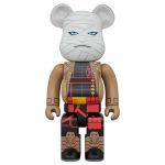 Bearbrick figure with wrapped face design and brown outfit, front view.