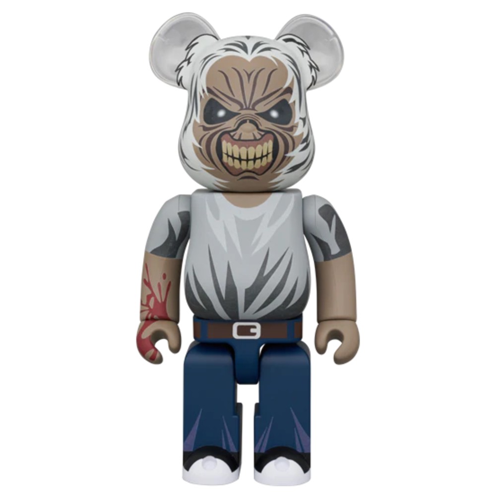 Bearbrick figure with fierce masked face, gray shirt, jeans, and tattooed arm.