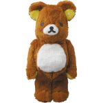 Fuzzy brown Bearbrick in a Rilakkuma-style costume with yellow ears and white belly.